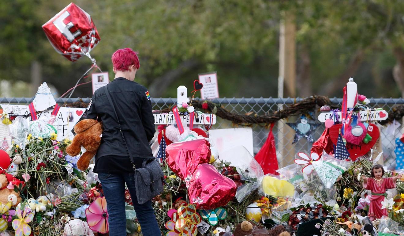 A Marjory Stoneman Douglas High School student looks at memorials to her fellow students in Parkland, Florida, on February 28. Photo: AFP
