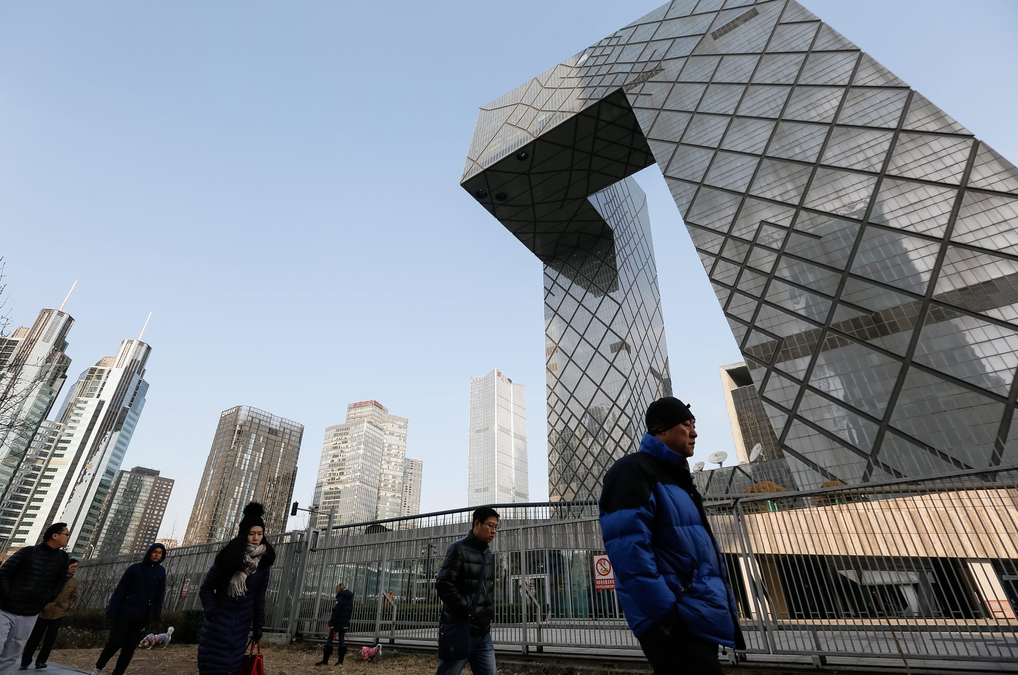People walk past the China Central Television (CCTV) headquarters in downtown Beijing, which Chinese people say resembles a pair of trousers. Photo: EPA 
