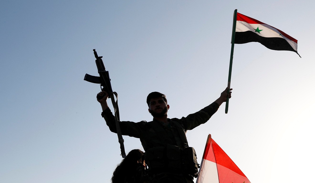 A Syrian soldier waves a flag during a protest against the air strikes in Damascus. Photo: Reuters