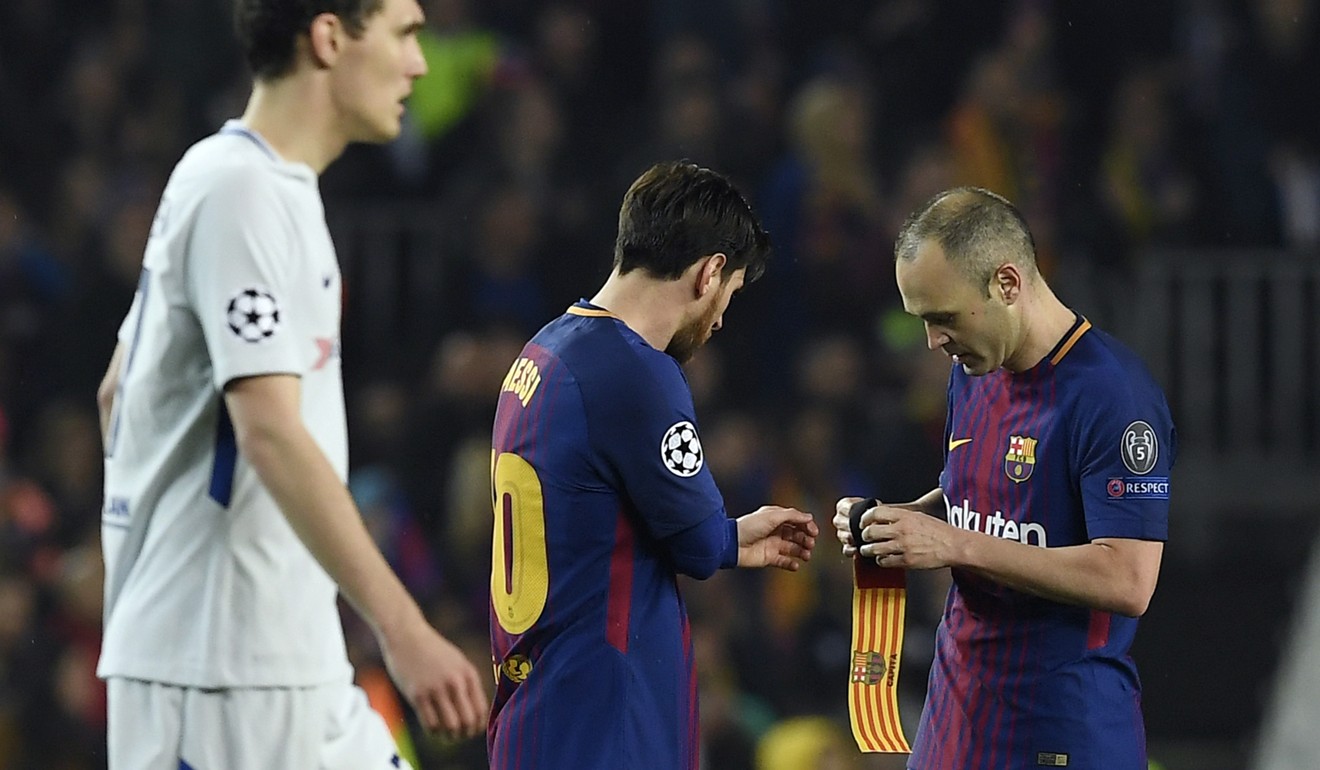 Iniesta hands the captain's armband to Barcelona's Argentinian forward Lionel Messi.