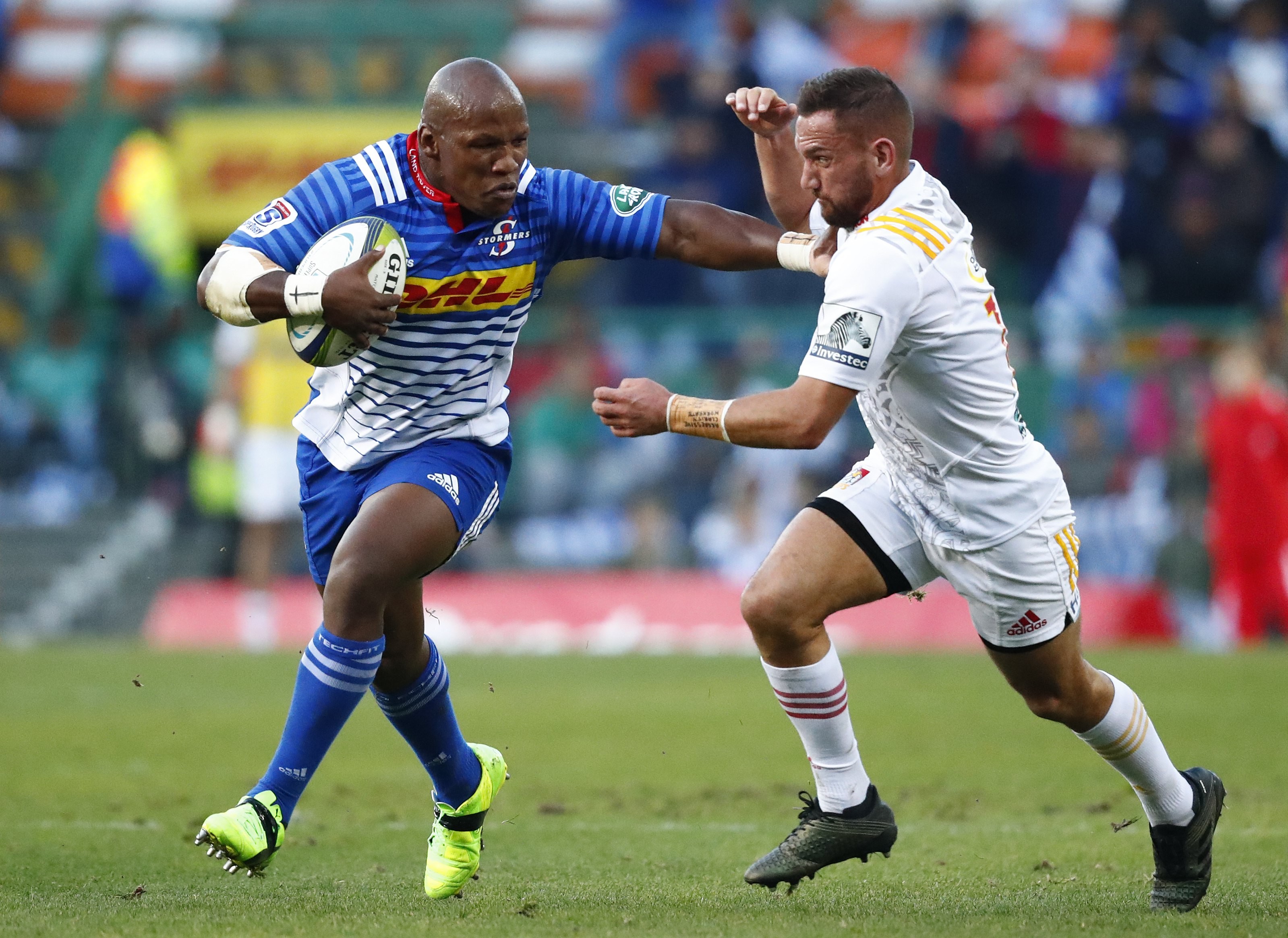 Bongi Mbonambi (left) from the Stormers hands off Aaron Cruden from the Chiefs. Photo: EPA