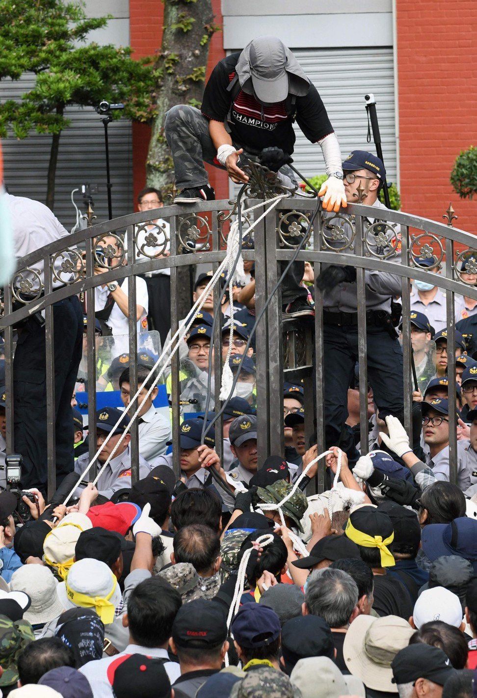 Protesters trying to pull down a gate at the parliament building. Photo: Agence France-Presse