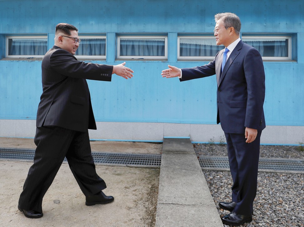 North Korean leader Kim Jong-un (left) and South Korean President Moon Jae-in greet each other at the border between their two countries in Panmunjom on Friday. Photo: Kyodo