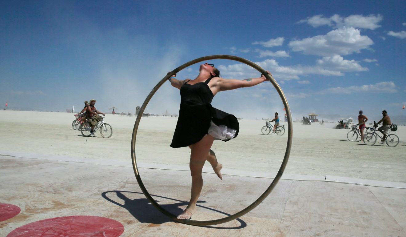 Burning Man participant Kylie Webb spins inside a metal hoop on a roller disco floor at the 2017 festival. Photo: Reuters
