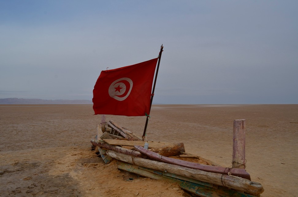 A boat-like structure with a Tunisian flag flying sits on a massive salt lake called Chott el Djerid in southern Tunisia. Photo: AP