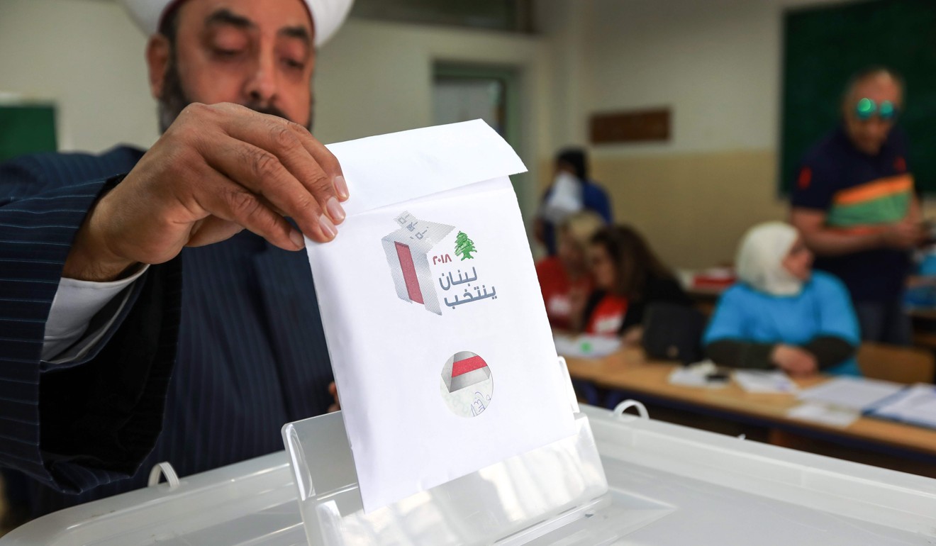 A Lebanese Sunni cleric puts his checked ballot in the box as he casts his vote. Photo: AFP