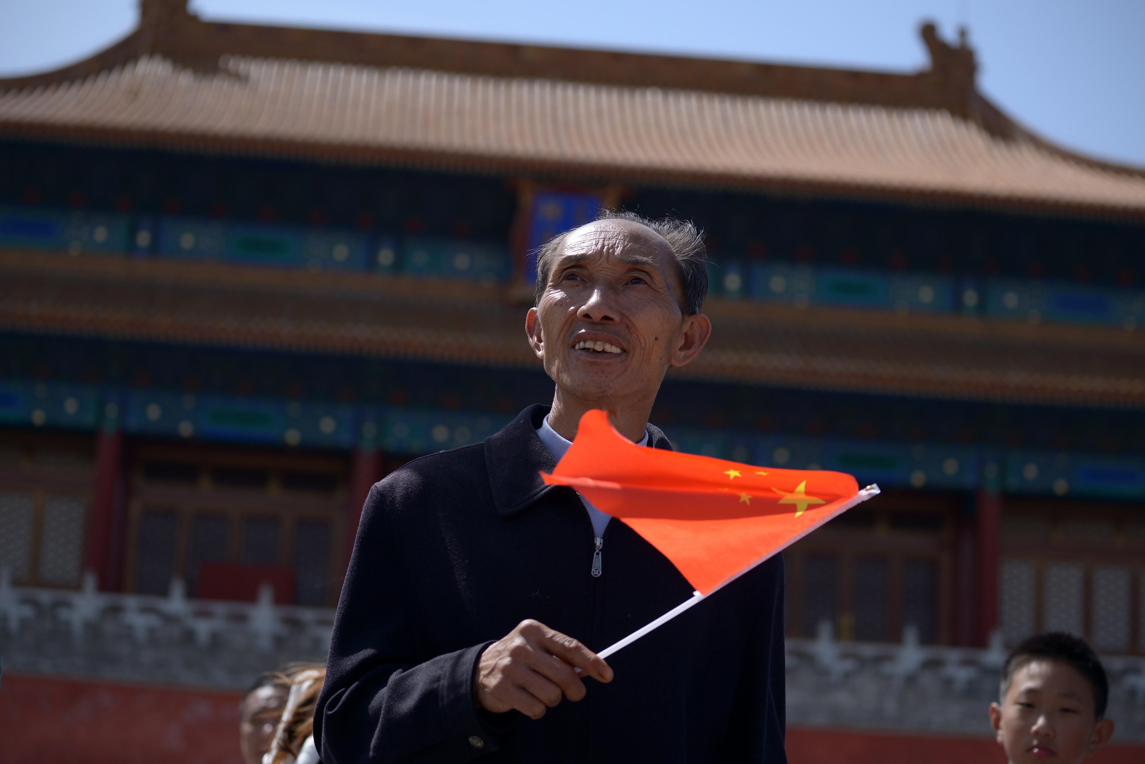A man waves a Chinese flag after visiting the Forbidden City in Beijing in May 2015. Photo: AFP 