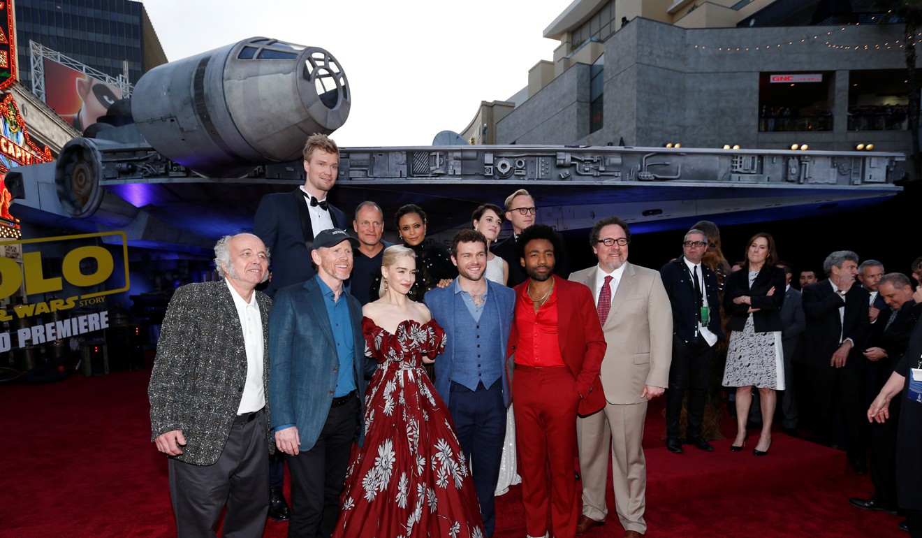 Cast members and director pose in front of a full-size Millennium Falcon specially built for the premiere. Photo: Reuters