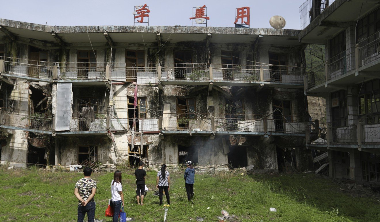 People mourn near a damaged building in Beichuan to mark the 10th anniversary of the Sichuan earthquake. Photo: Chinatopix
