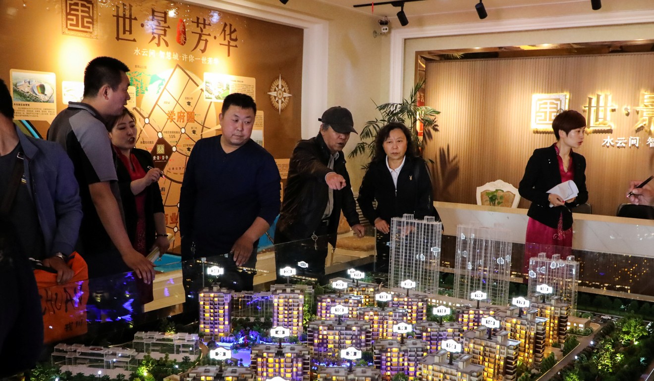 Visitors look at a model of residential buildings in Dandong New Zone, at a showroom earlier this month. Photo: Reuters