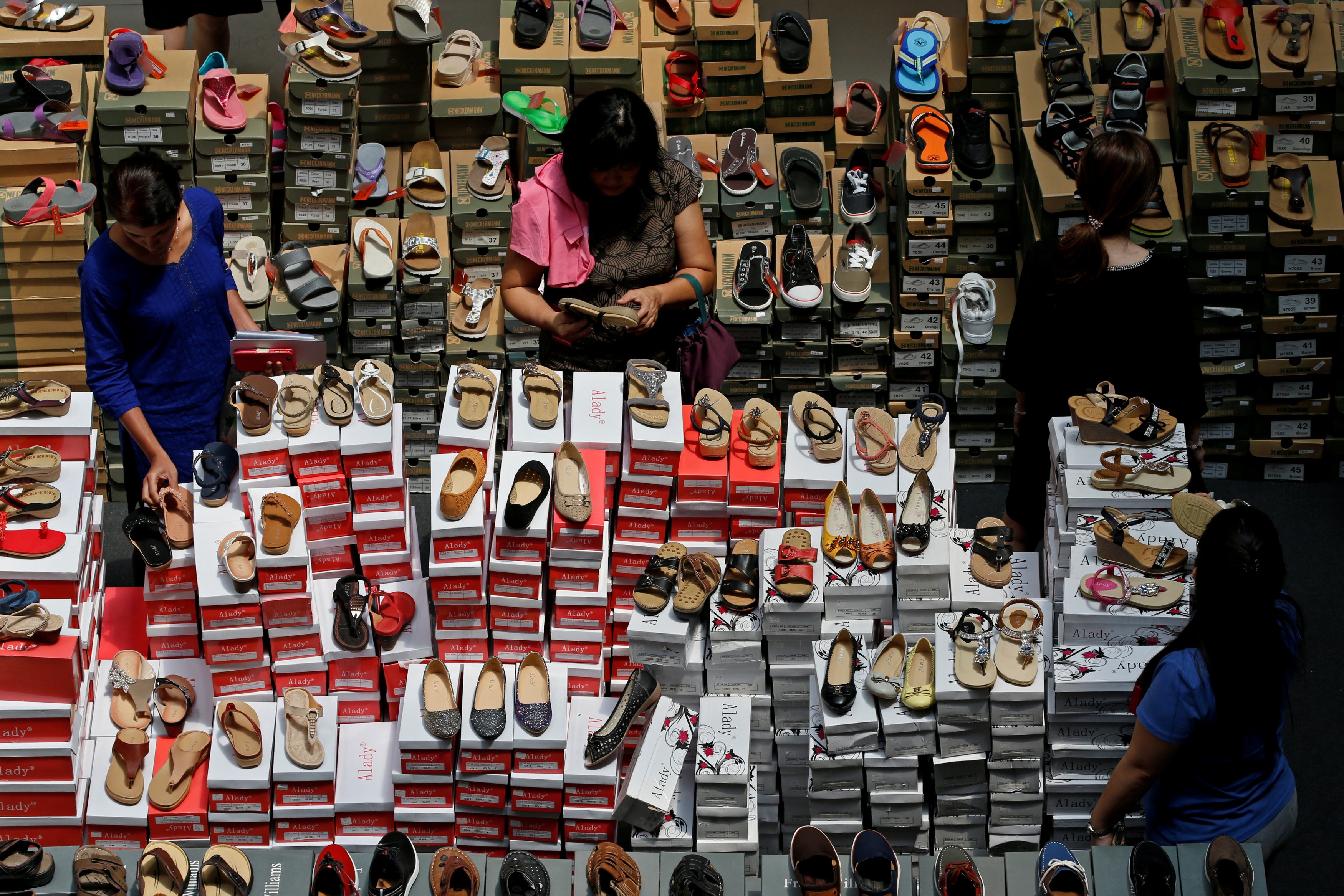 People shop for shoes at a mall in Singapore in May 2016. Online shopping has gained in popularity, but not brought down prices for every customer. Photo: Reuters