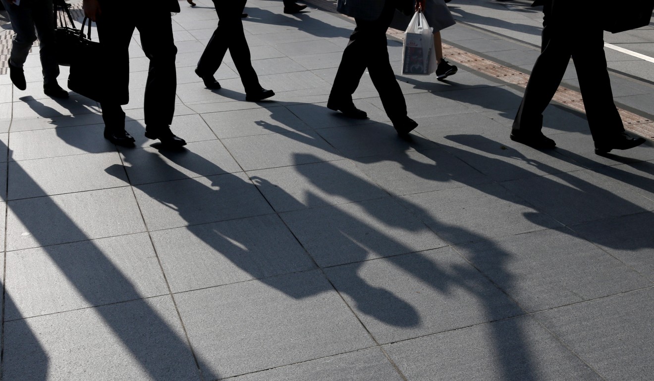 Morning commuters cast shadows on a sidewalk in Tokyo. If the US economy is hit by a downturn, the rest of the world won’t be spared. Photo: Bloomberg 