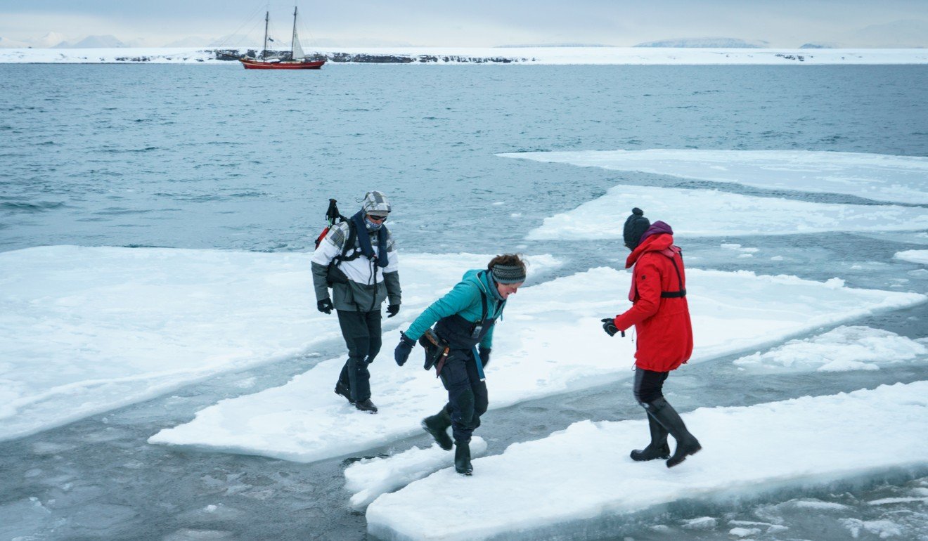Guests hop across broken plates of sea ice washed into Ymerbukta. Photo: Tessa Chan