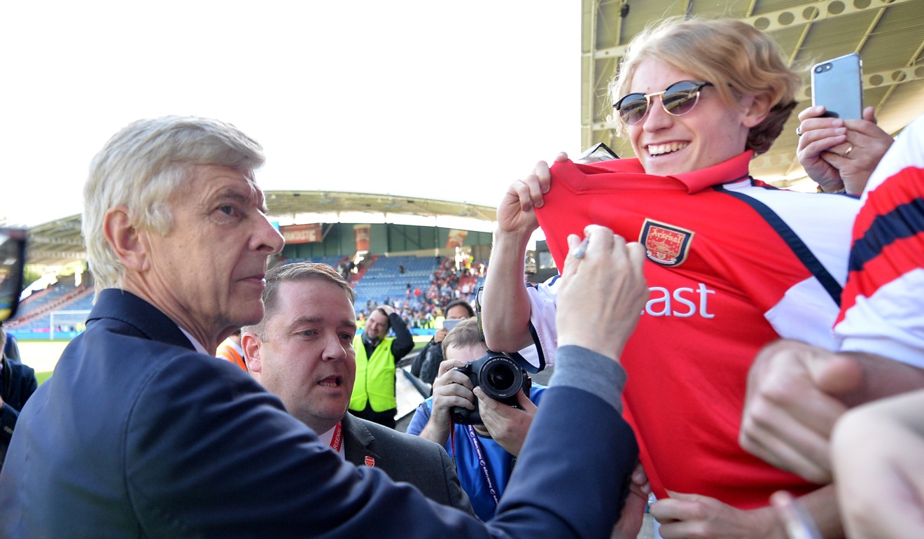 Arsenal manager Arsene Wenger signs an autograph for a fan after the match on May 13. Photo: Reuters