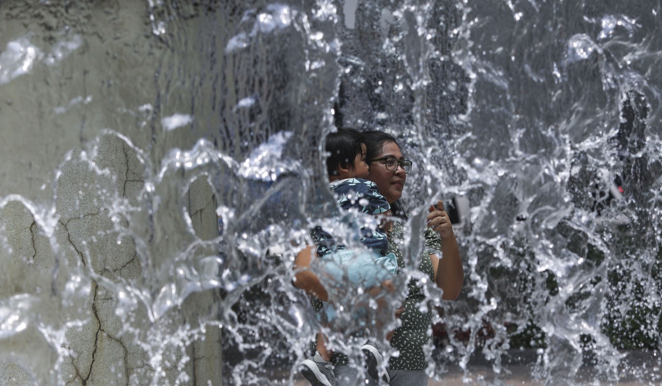 People try to cool down at a water fountain in Hong Kong Park. Photo: Sam Tsang