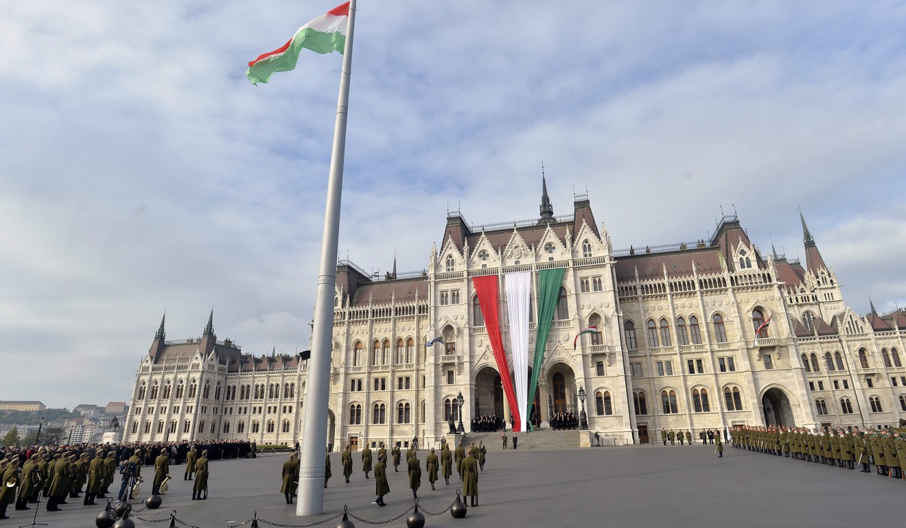 Hungarian honour guards hoist the national flag during an official celebration of the national holiday marking the anniversary of the Hungarian Revolution in front of the Parliament building in Budapest in October 2015. On October 23, 1956, Hungarians took to the streets to protest against communist rule and Soviet oppression in a revolt that was violently suppressed by Soviet forces, prompting dozens of Hungarian athletes then competing in the Melbourne Summer Olympics to refuse to return home. Photo: EPA