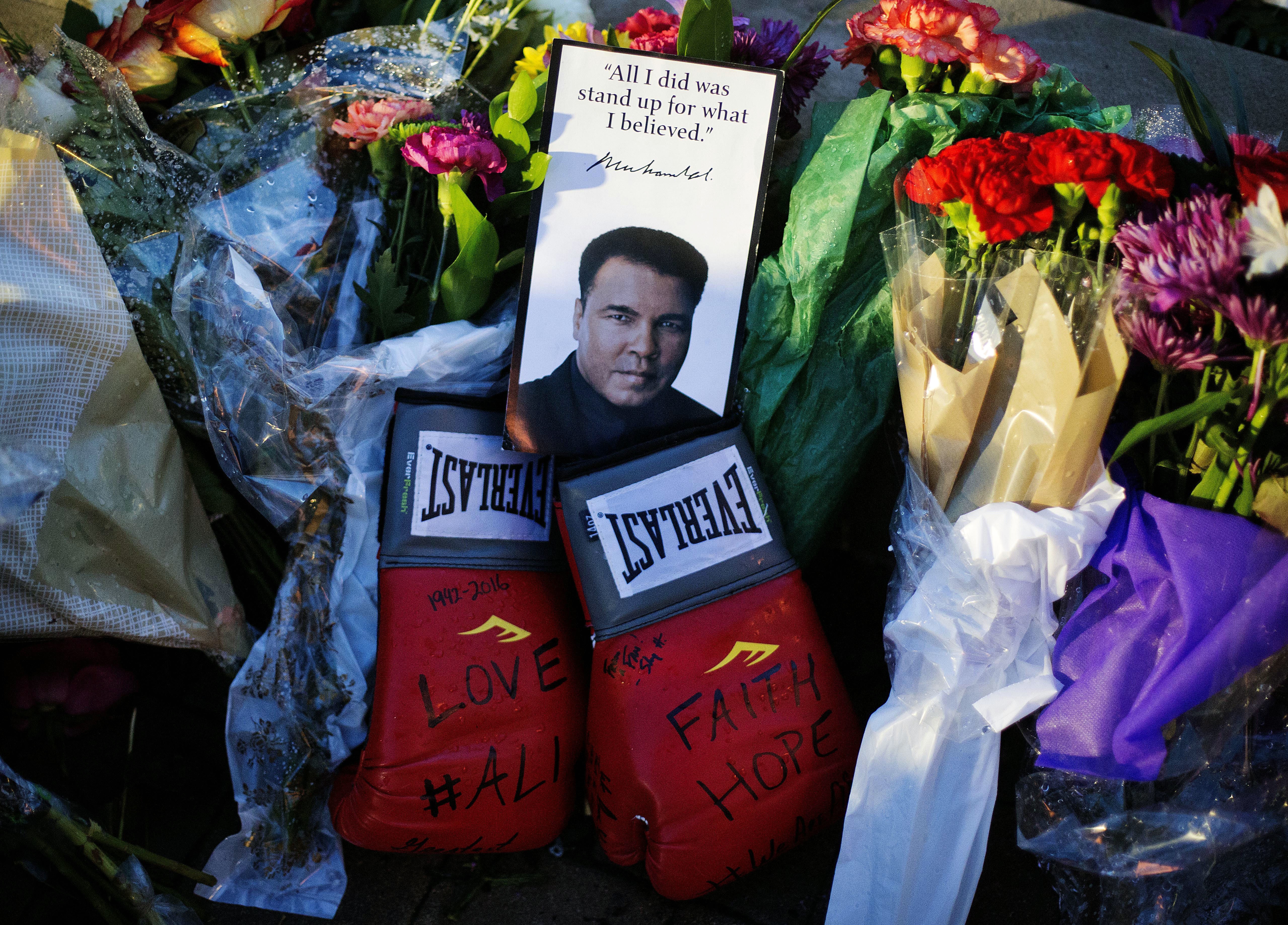 Boxing gloves and a message sit among flowers at a makeshift memorial to Muhammad Ali after he died in 2016 at age 74. President Donald Trump is considering issuing a presidential pardon for Ali, along with some 3,000 others. Photo: AP