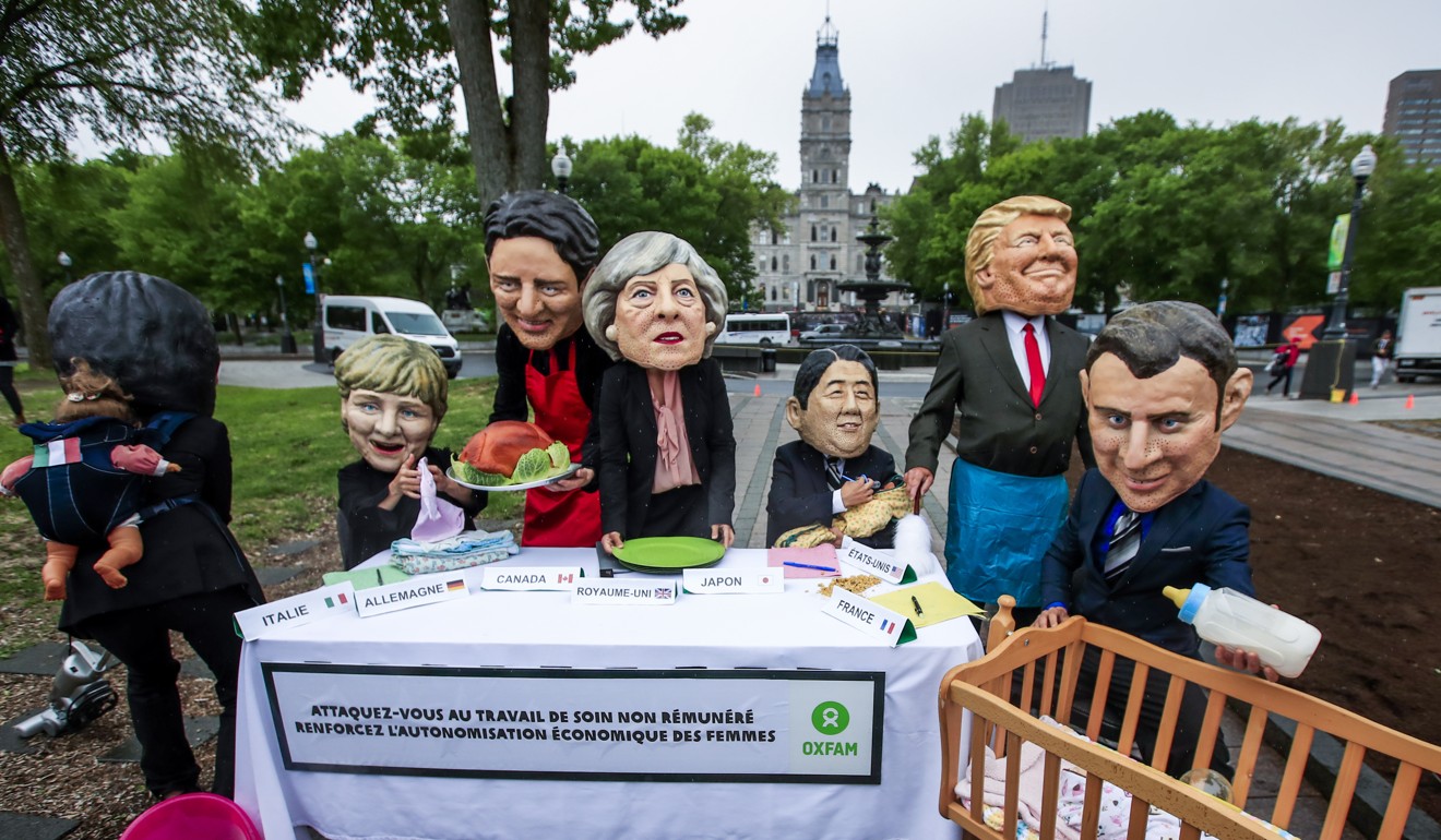 Oxfam activists imitate the leaders of the G7 nations as they protest in support of the roles women take in managing their homes and working in paid jobs outside the home before the start of the G7 Summit in Quebec City, Quebec. Photo: EPA