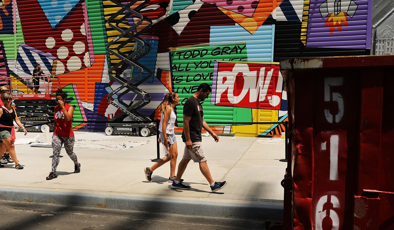 Pedestrians walk past a public mural project at the World Trade Center site in Lower Manhattan, New York City. Silverstein Properties, in partnership with the Port Authority of New York and New Jersey, has invited selected artists to enliven the area with colourful murals that will be on display for at least one year. Photo: Getty Images