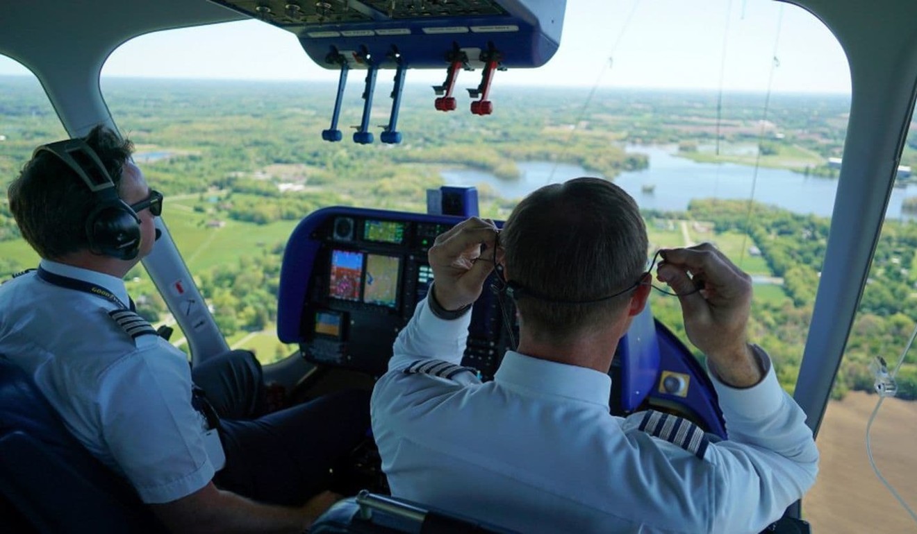 Goodyear Chief Pilot Michael Dougherty lifts his earpiece off during an May 2017 training flight with William Bayliss over Akron, Ohio. Photo: AP