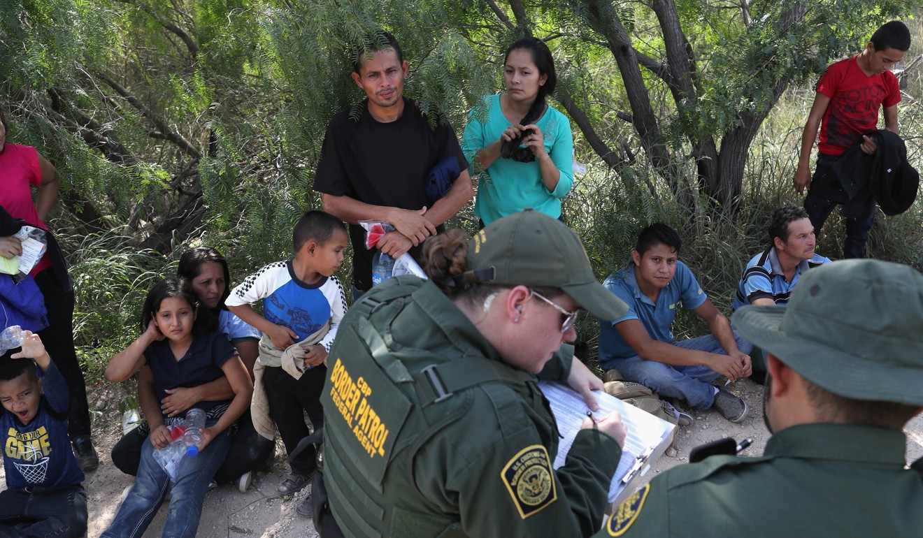 Central American asylum seekers wait as US Border Patrol agents take groups of them into custody on June 12 near McAllen, Texas. Photo: Agence France-Presse