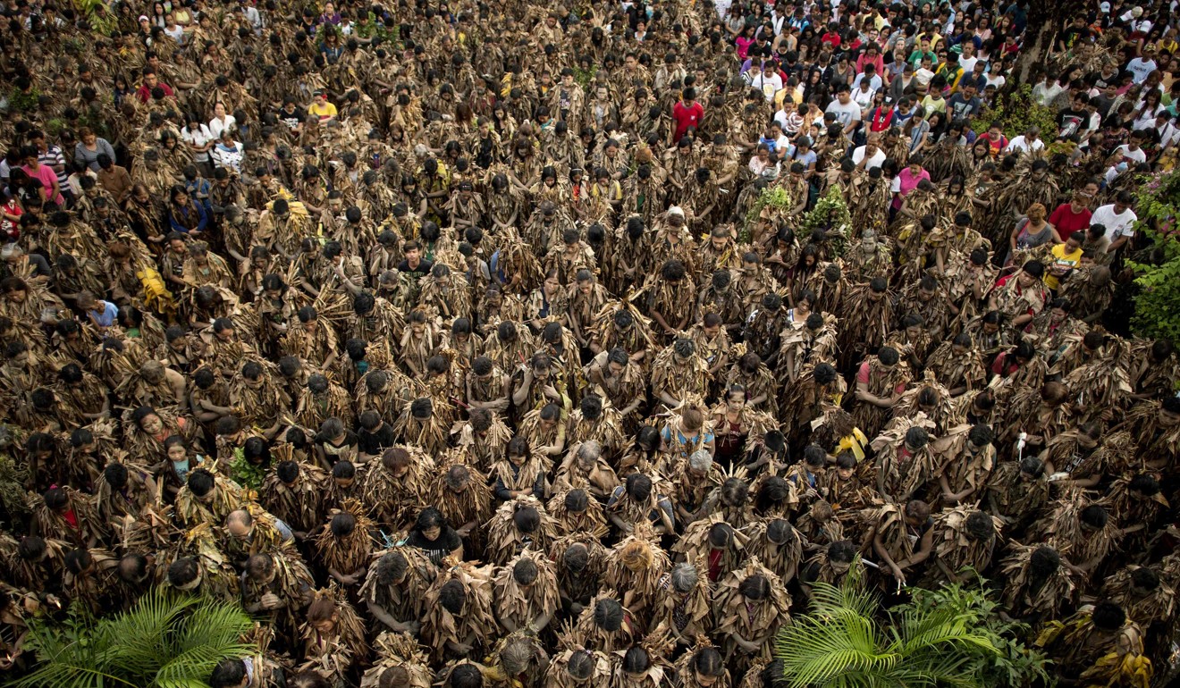 Devotees wearing costumes made of banana leaves attend a mass. Photo: AFP