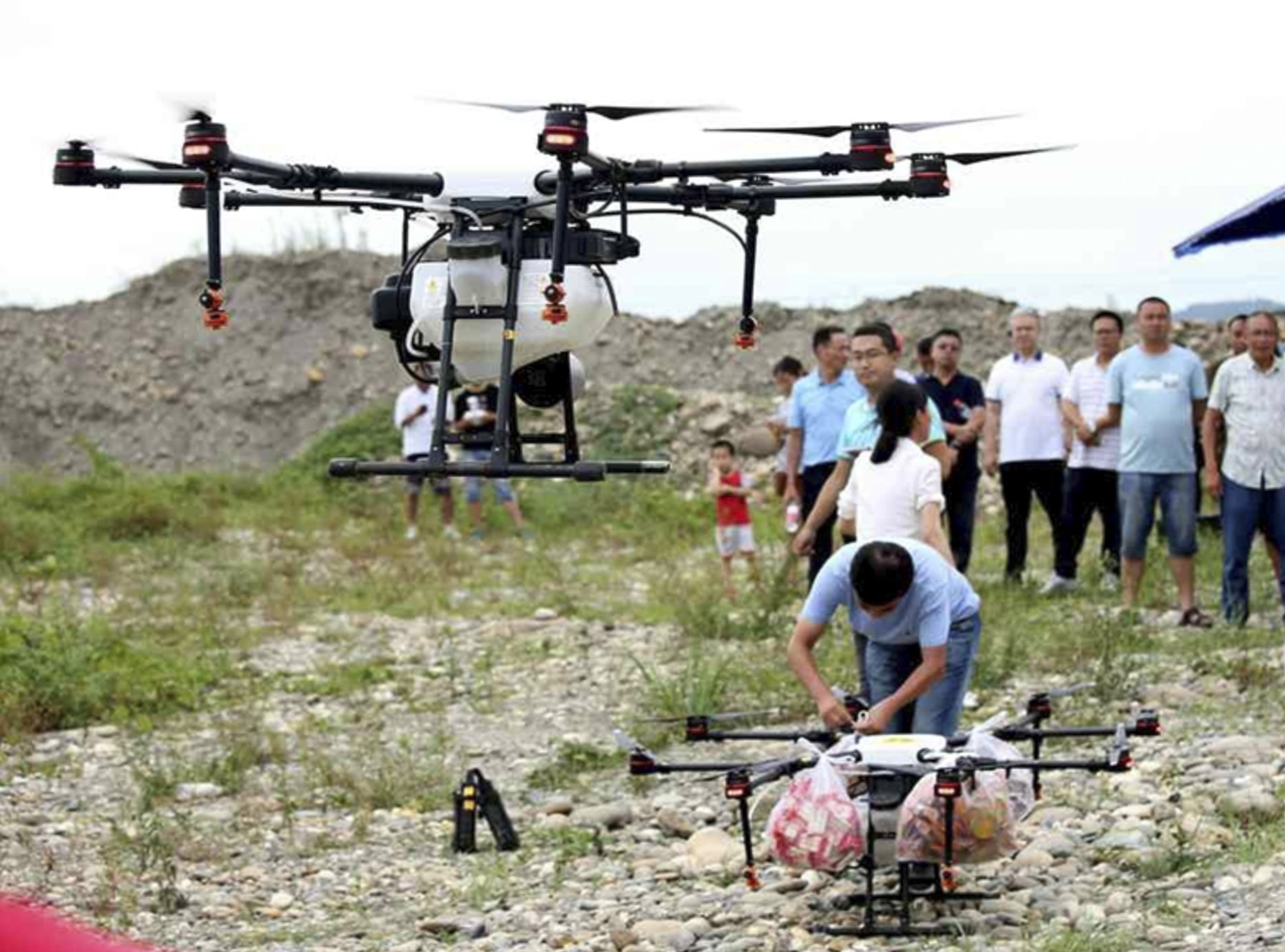 Onlookers watch the drones being loaded with supplies. Photo: scol.com.cn