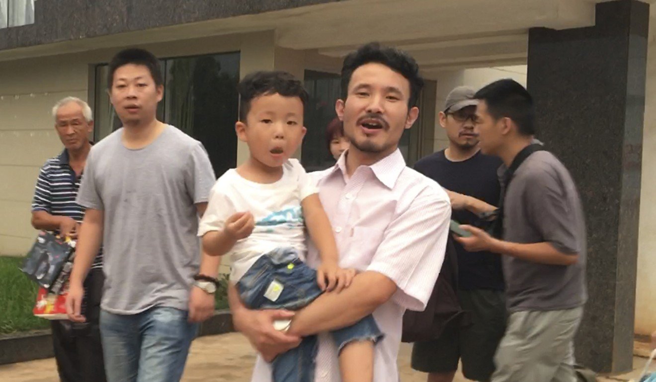 Chinese labour activists Hua Haifeng (carrying his son, Bo Bo) and Li Zhao (second from left) leave a police station after being released in Ganzhou, China, in June 2017. They were arrested while investigating abuses at Ivanka Trump's Chinese suppliers. Photo: AP