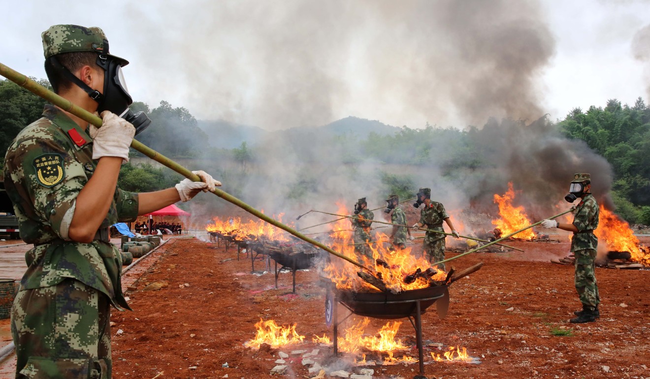 Border police officers set fire to illicit drugs in Dehong Dai and Jingpo Autonomous Prefecture in Yunnan province on June 26. A total of 6.63 tonnes of seized drugs including heroin, methamphetamines, opium and morphine were destroyed there on the International Day Against Drug Abuse and Illicit Trafficking. Photo: Xinhua