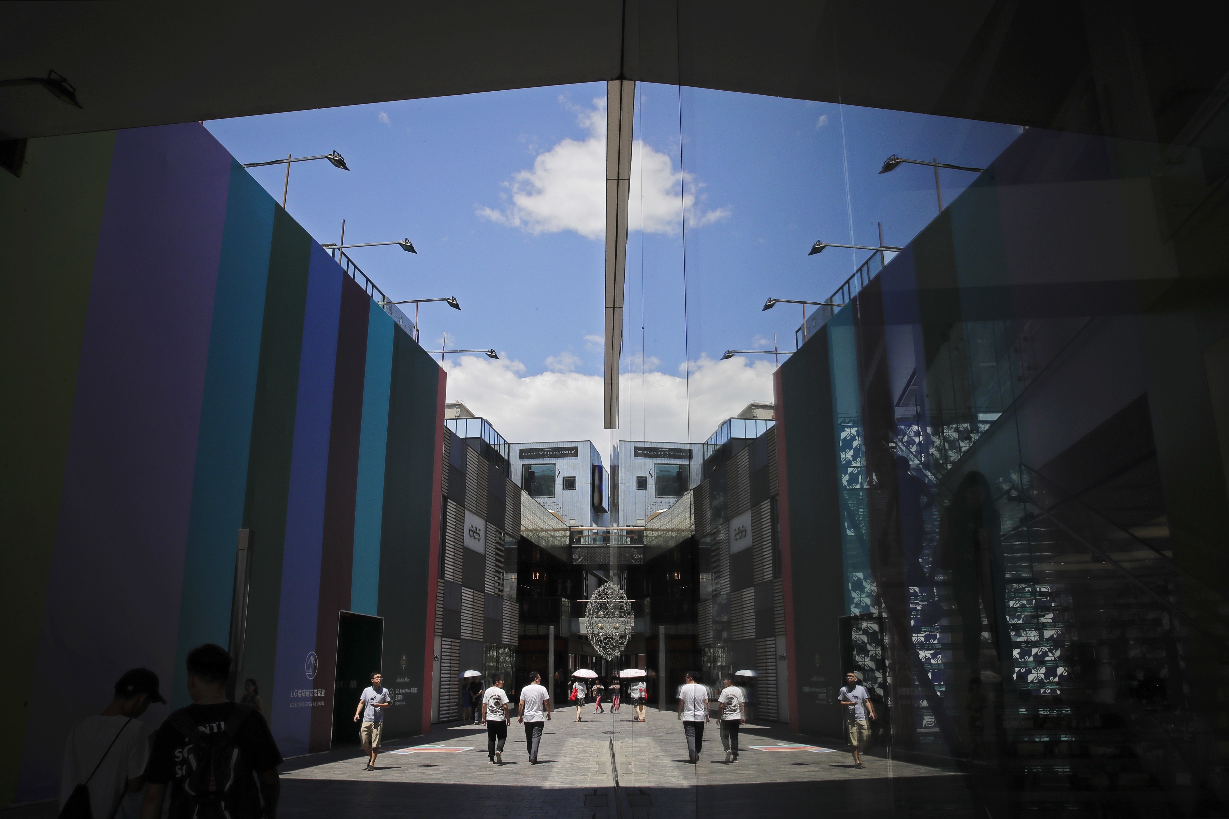 People walking through a popular shopping mall in Beijing are reflected in the glass panels of an Apple Store. The benefits of open, vibrant markets extend well beyond foreign businesses. Yet, China still ranks as one of the most restrictive countries for FDI, according to an OECD report. Photo: AP