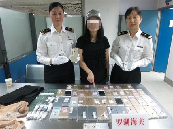 Customs officers caught this woman trying to smuggle 102 iPhones and 15 Tissot watches out of Hong Kong.