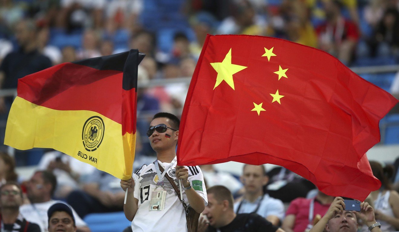 A fan holds German and Chinese flags before the match against Sweden. Photo: AP