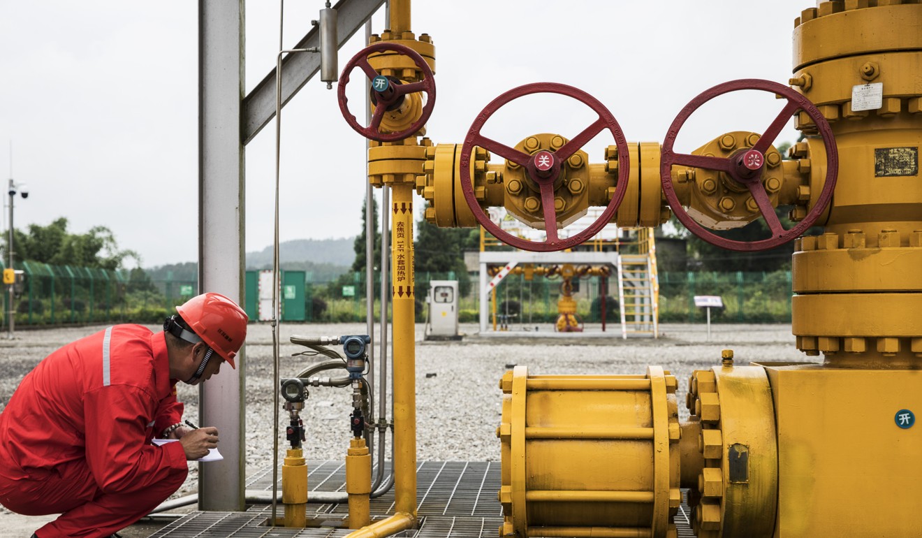 An employee takes gauge readings at a shale gas well at the Fuling shale gas project site. Photo: Bloomberg