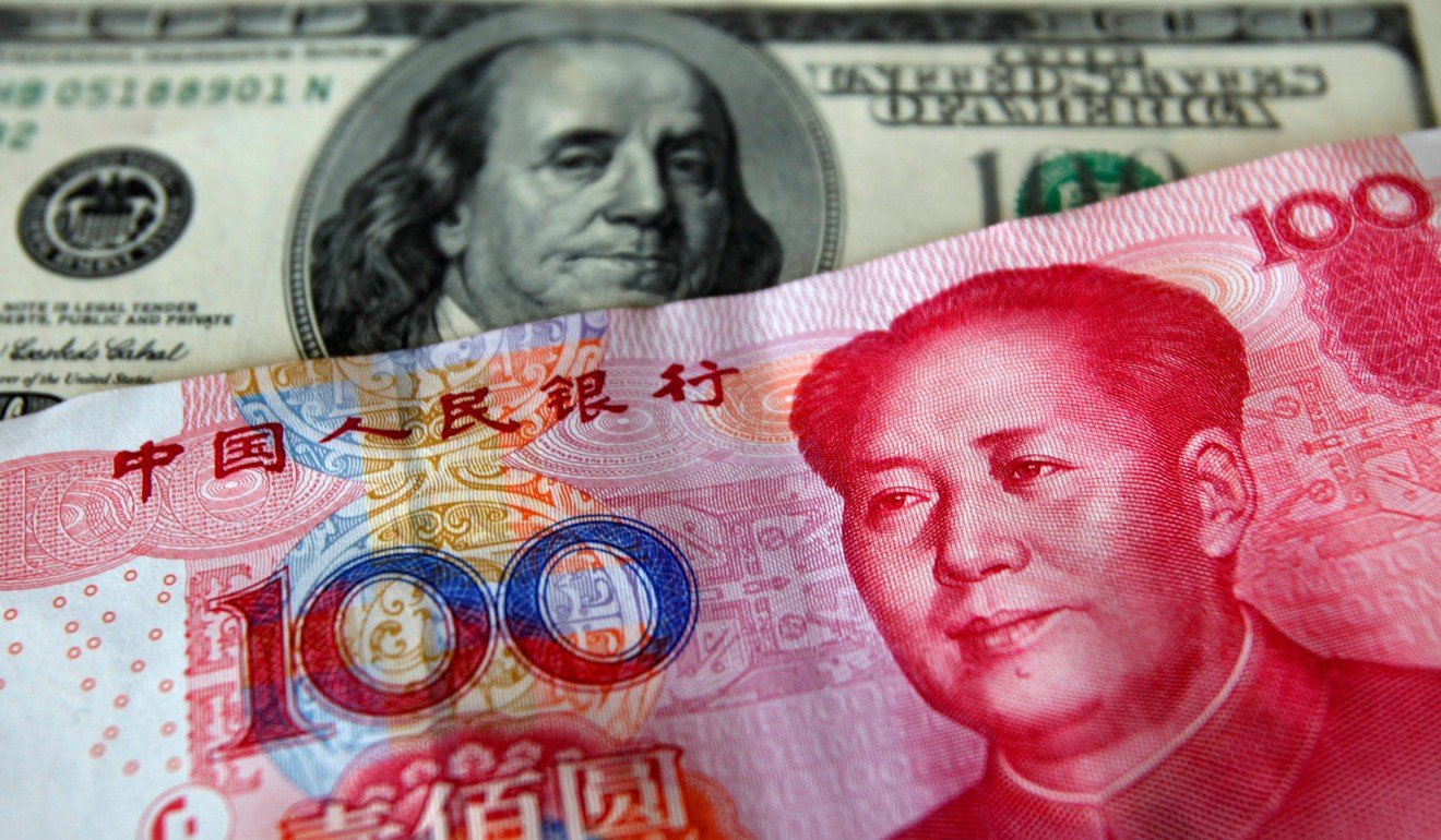 A yuan banknote is displayed next to a US dollar banknote. Photo: Reuters