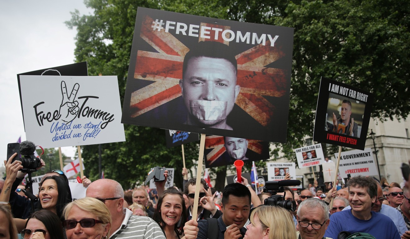 Demonstrators hold placards supporting EDL founder Tommy Robinson and US President Donald Trump in London. Photo: AFP
