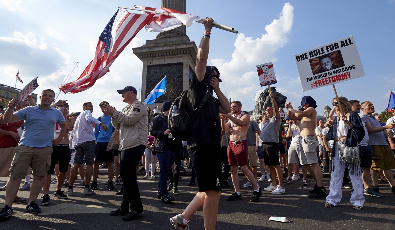 Demonstrators hold placards supporting EDL founder Tommy Robinson and US President Donald Trump in London. Photo: AFP