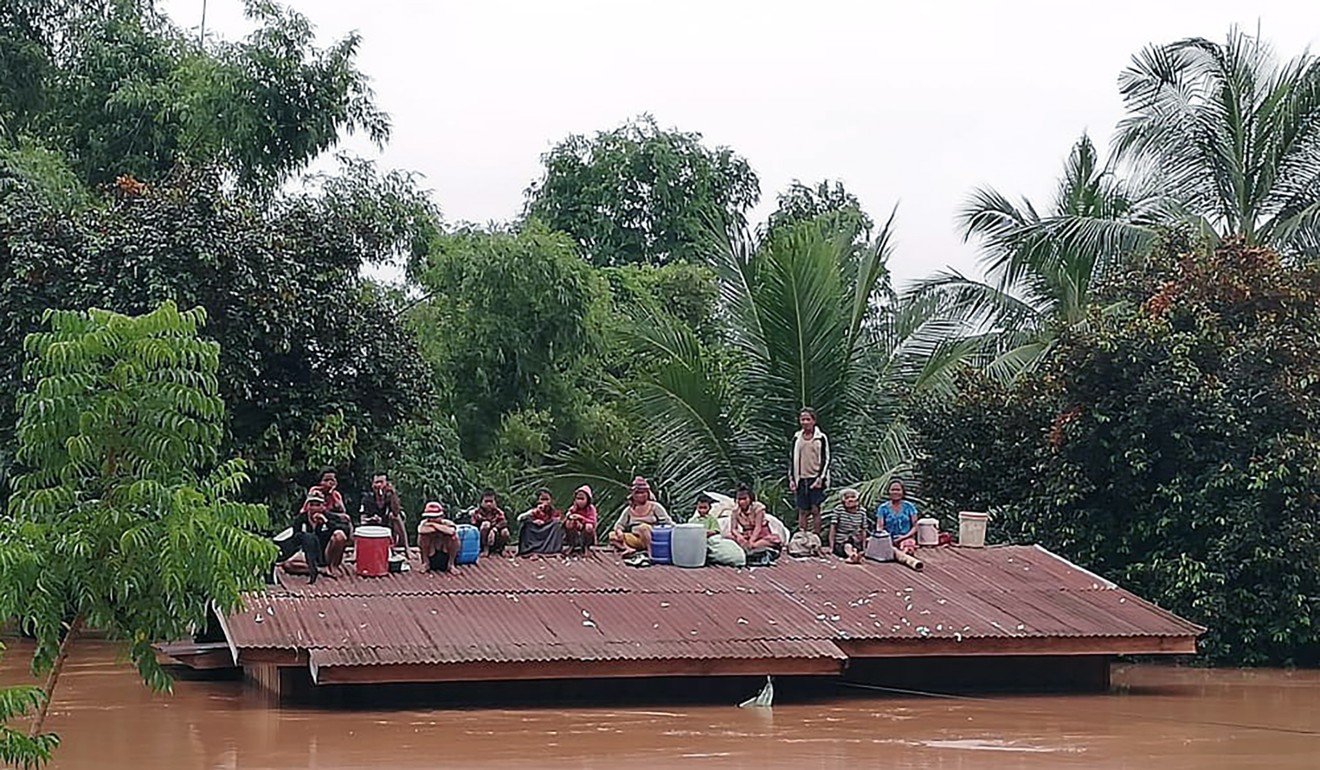Villagers take refuge on the roof of a house after the Xe Pian Xe Nam Noy dam collapsed. Photo: AP