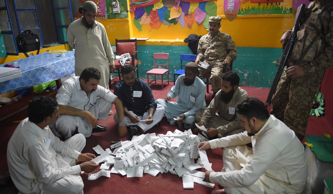 Pakistani election officials count ballot papers after polls closed at a polling station in Rawalpindi on July 25, the day vote-counting began for an election marred by a bloody suicide bombing and claims of military interference. Photo: AFP