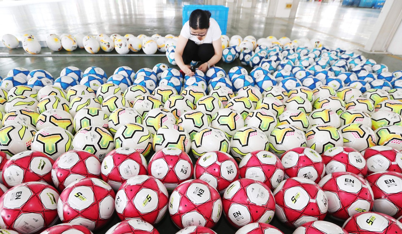 A Chinese employee works at a factory that produced soccer balls for the Fifa World Cup in Haimen in China’s eastern Jiangsu province on May 15. A devalued renminbi would make China’s exports cheaper, but would undermine the government’s goal of boosting domestic consumption rather than export-led growth. Photo: AFP