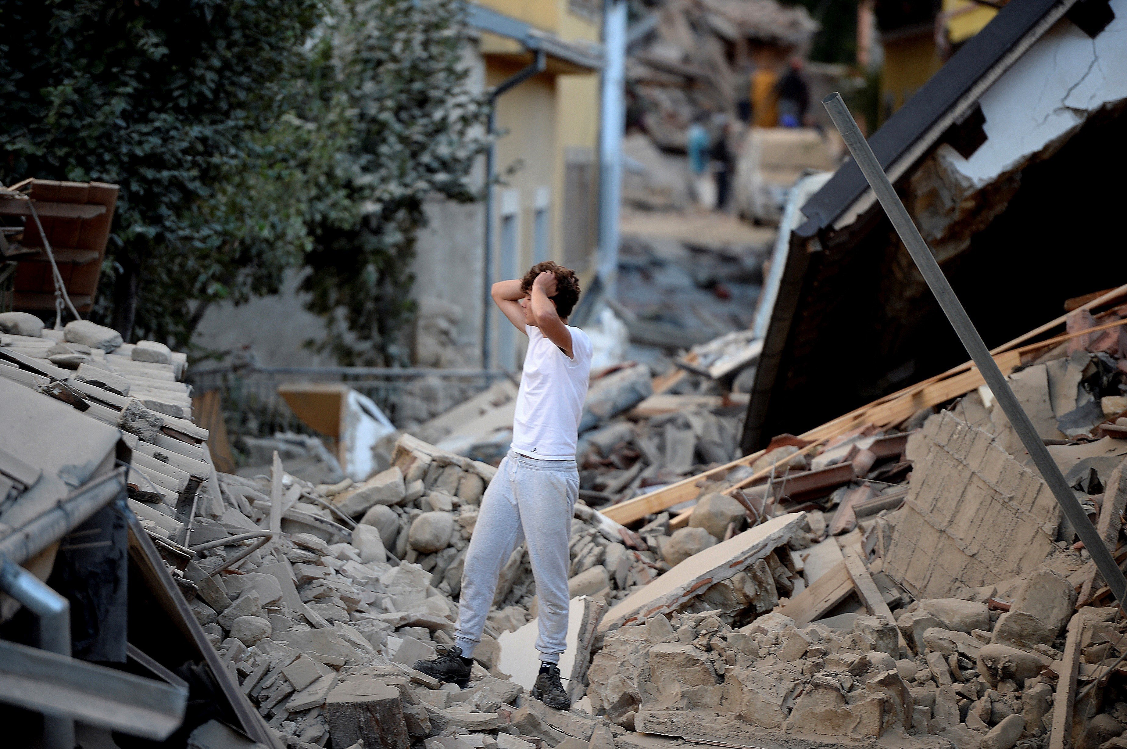 A man stands among damaged buildings after a strong earthquake hit Amatrice in central Italy on August 24, 2016. Photo: AFP