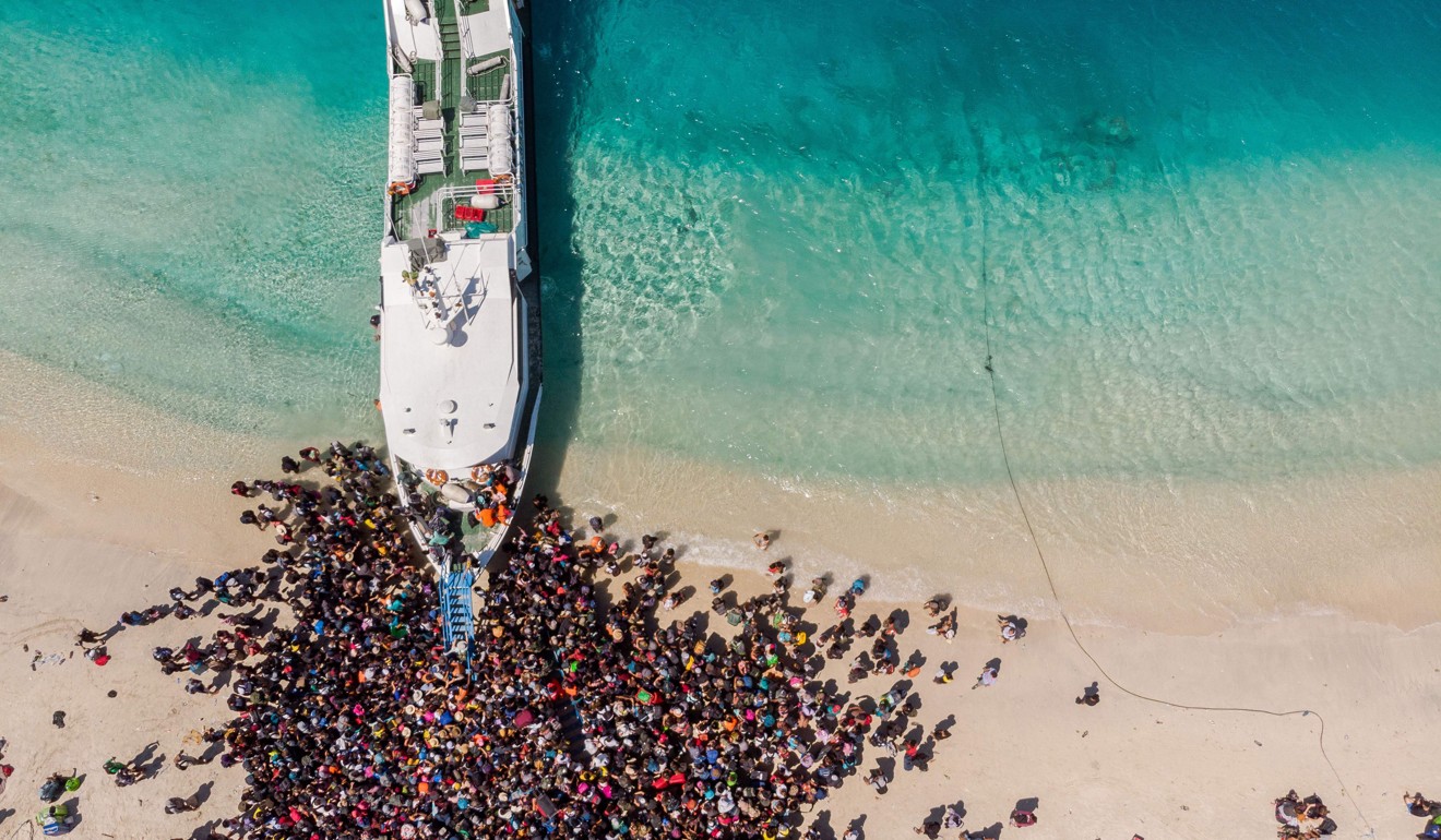 People crowd a beach as they wait to be evacuated from Gili Trawangan island. Photo: Melissa Delport