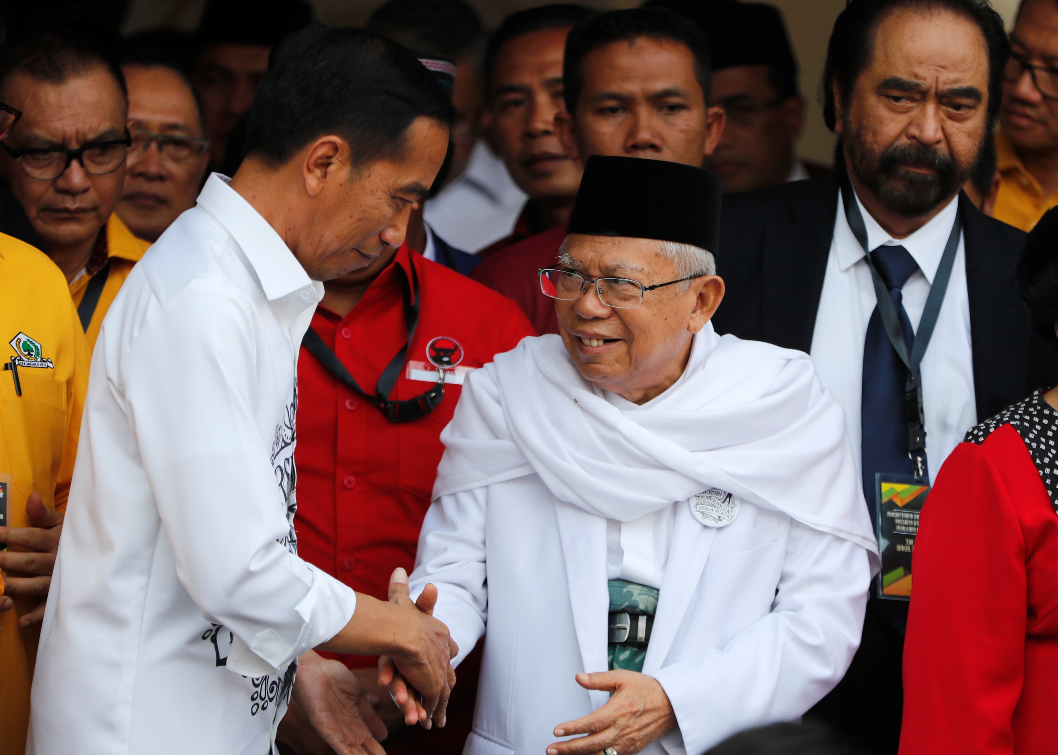 Indonesian President Joko Widodo, left, with his vice-presidential running mate Ma’ruf Amin while greeting supporters in Jakarta on Friday. Photo: Reuters