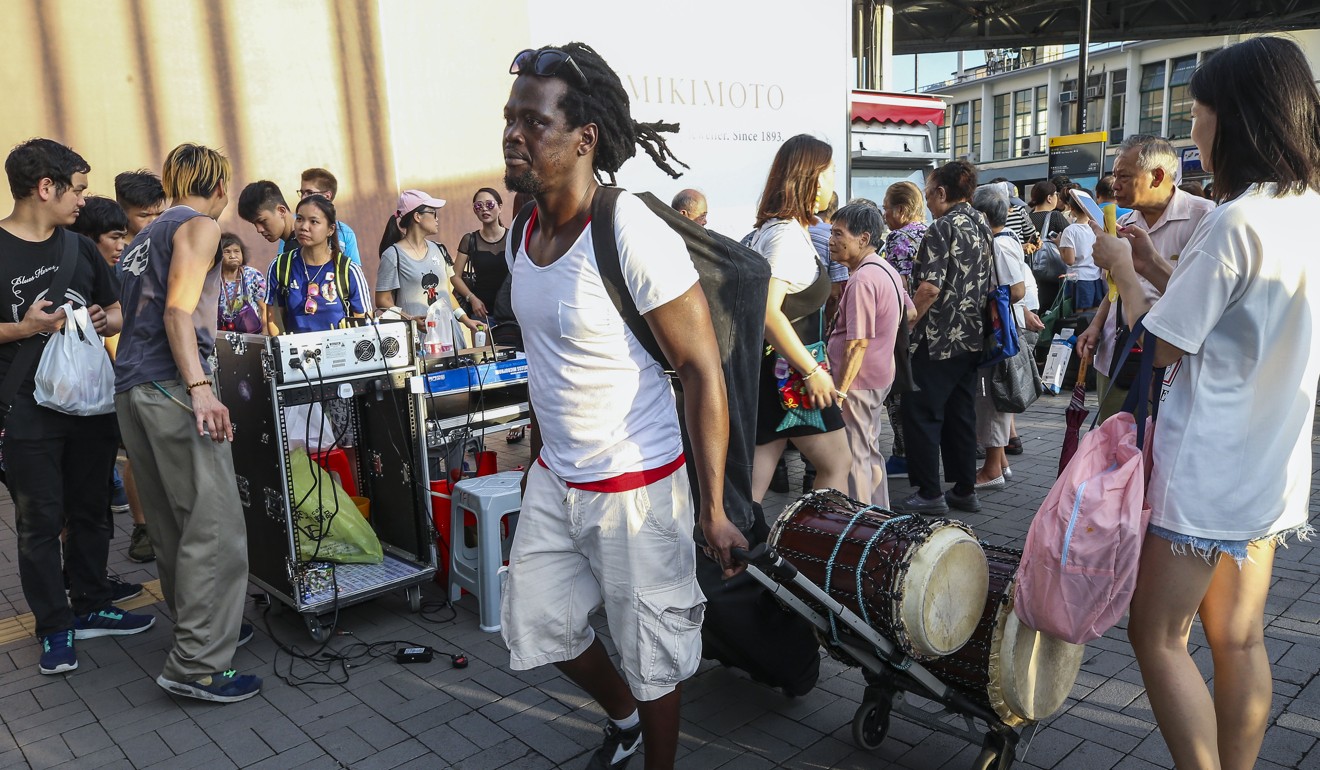 Kande Mansaly, 41, who usually plays the African drums on weekends at the Star Ferry pier, said newcomers from Mong Kok did not respect the regulars. Photo: Dickson Lee