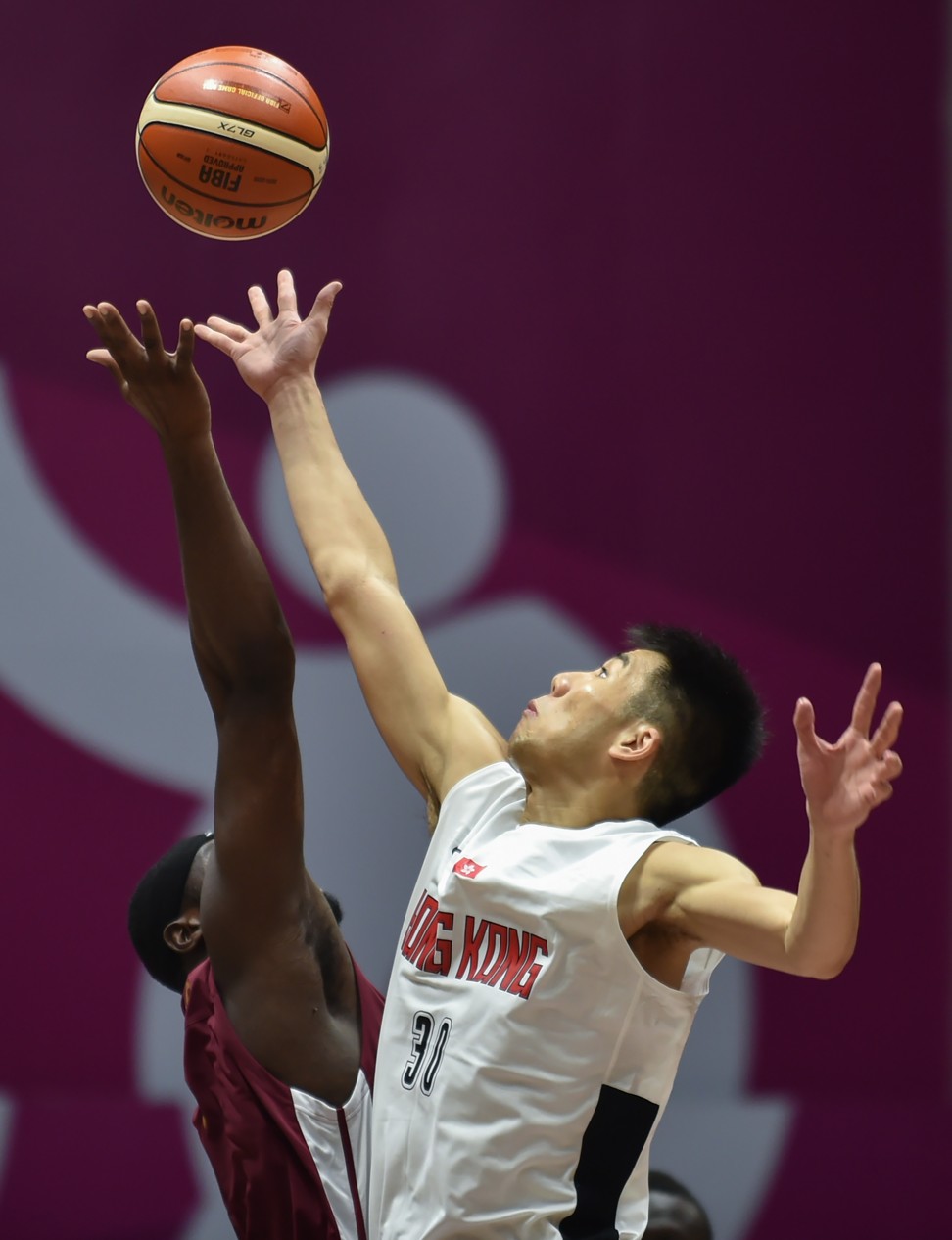 Qatar's Tanguy Ngombo (left) competes for the ball with Hong Kong's Wu Cheuk-pan.