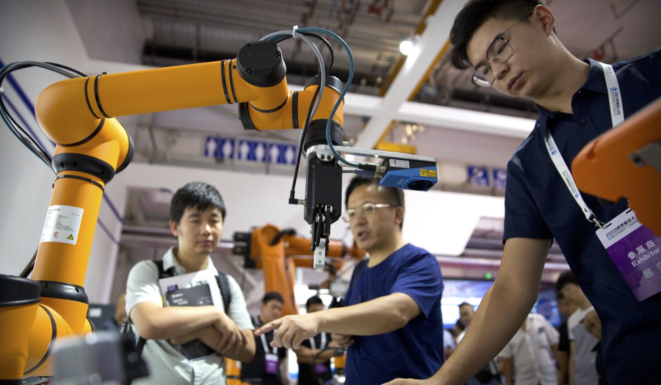 Visitors look at a manufacturing robot from Chinese robot maker Aubo Robotics at the World Robot Conference in Beijing on Wednesday. Photo: AP