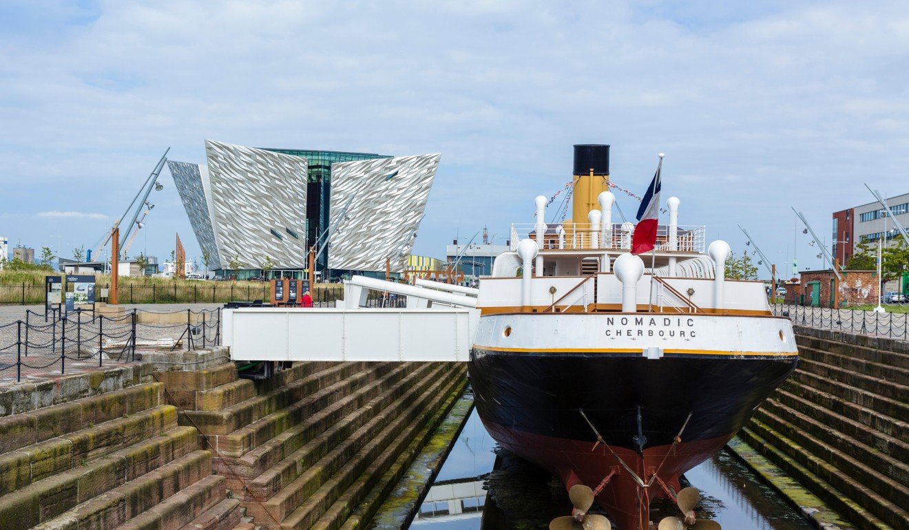 The Titanic Belfast museum stands behind the SS Nomadic, in Belfast, Northern Ireland. Picture: Alamy