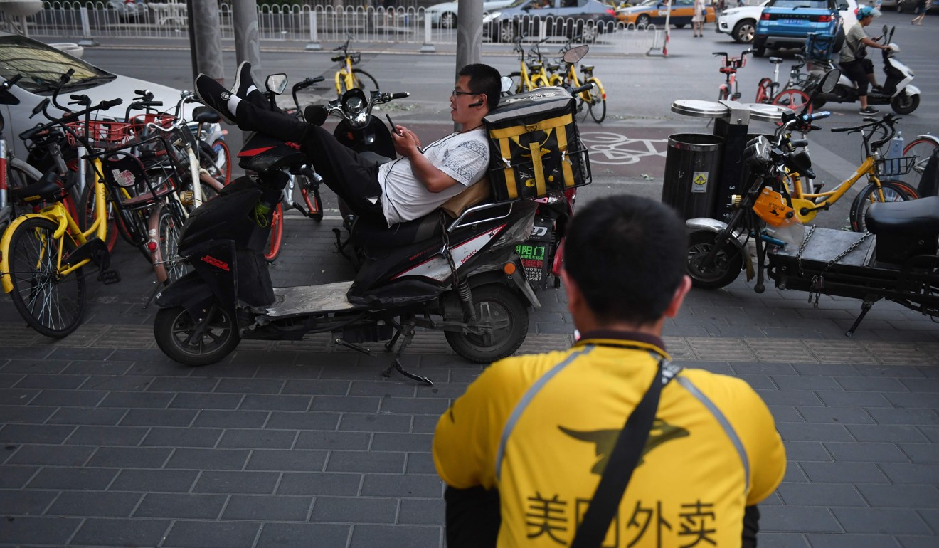 Meituan delivery riders wait for food delivery assignments in Beijing on June 26, 2018. The online services giant Meituan-Dianping filed for an initial public offering in Hong Kong on June 25. Photo: AFP