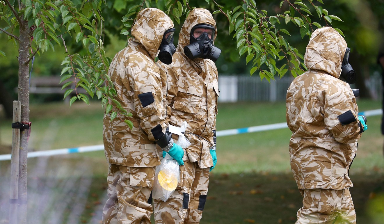 People in military hazardous material protective suits collect an item in Queen Elizabeth Gardens in Salisbury. Photo: Reuters