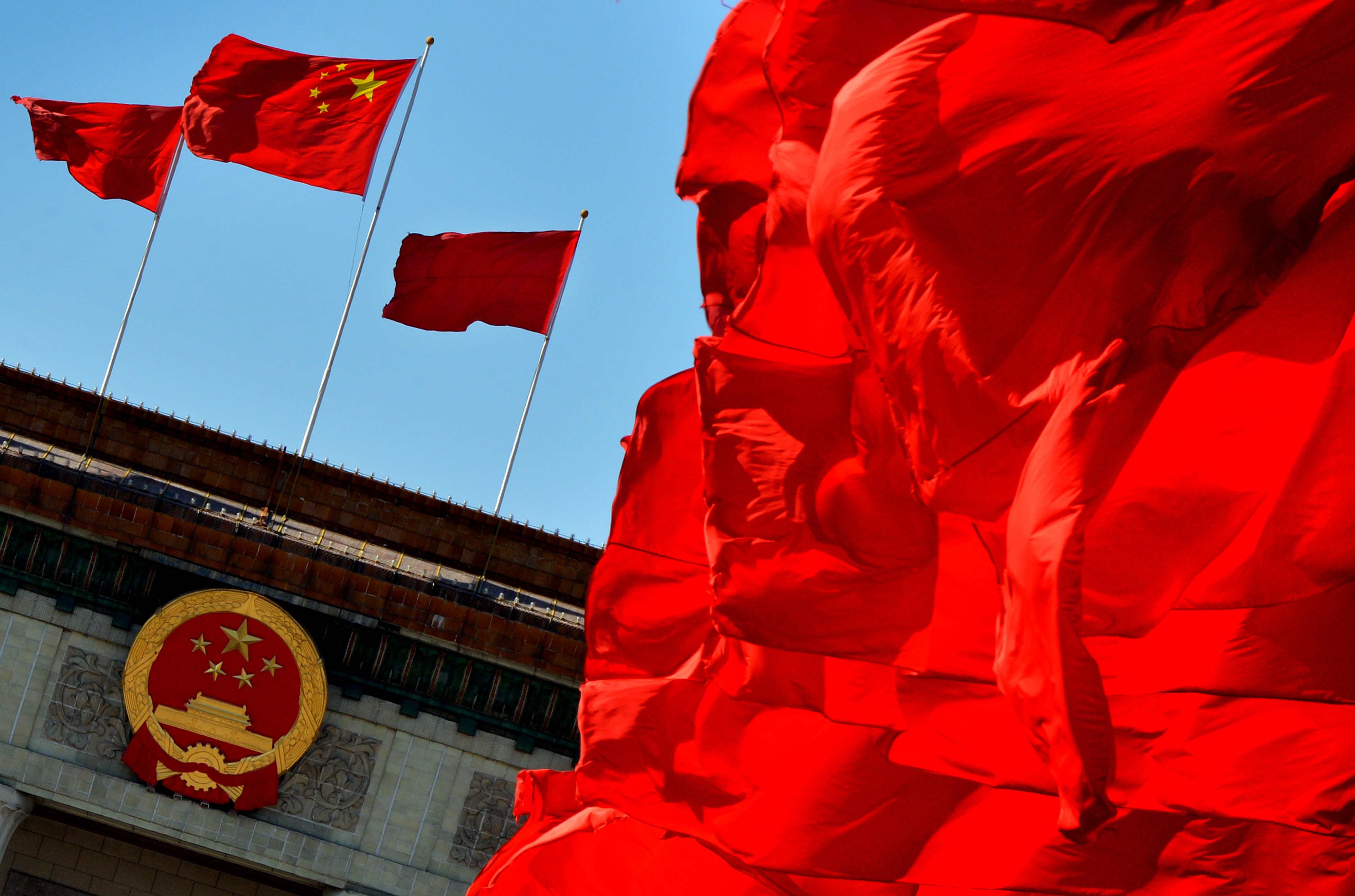 Chinese flags fly over the Great Hall of the People, the site of the Communist Party Congress, in Beijing. One problem for China’s party is that state-owned enterprises play a vital role in sustaining one-party rule, but the bloated and inefficient firms suck scarce resources out of the economy. Photo: AFP