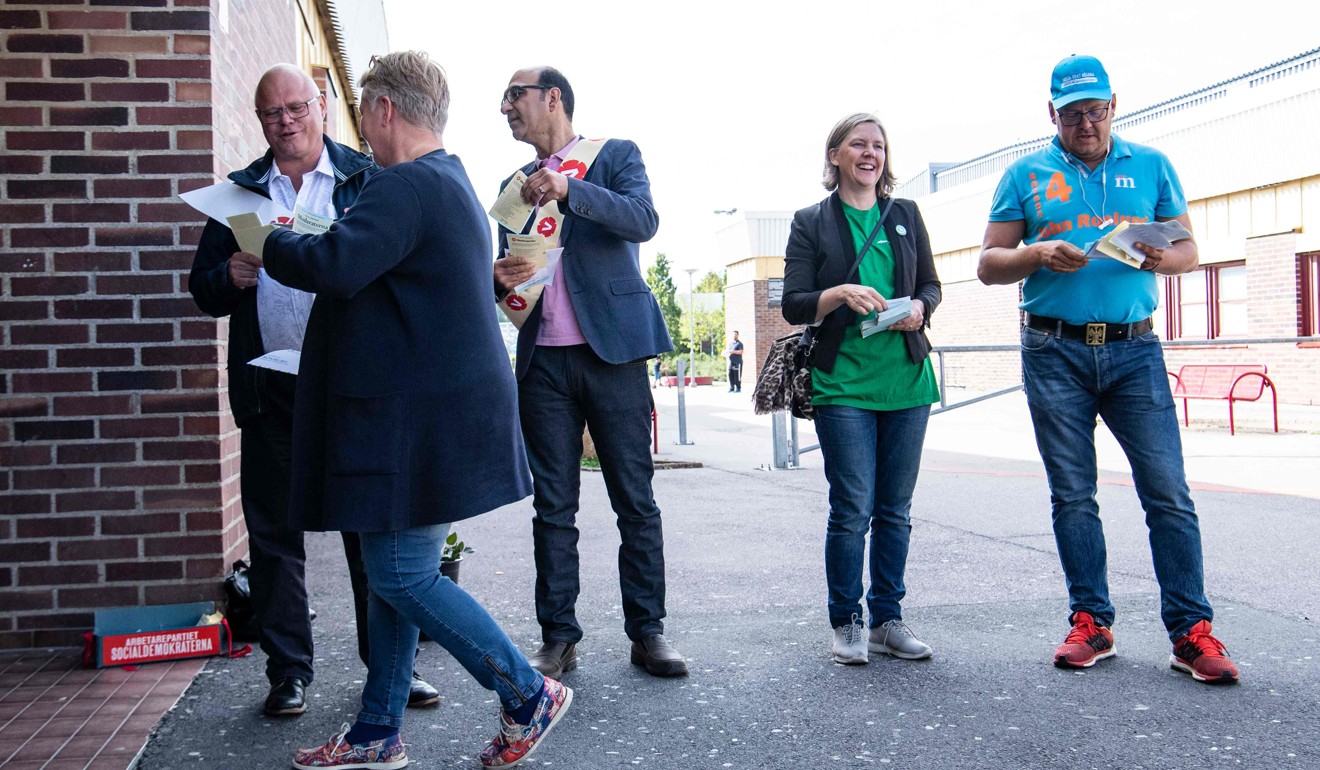 Swedish Minister for the Environment Karolina Skog handing out ballot papers outside a polling station at Kroksbäck school in Malmö on September 9, 2018. Photo: Photo: AFP